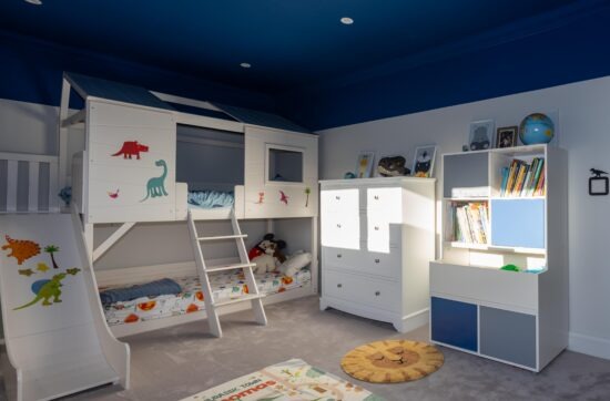 Children's bedroom with bespoke bunk beds, a slide and built-in storage at Haven Lodge, St Albans.